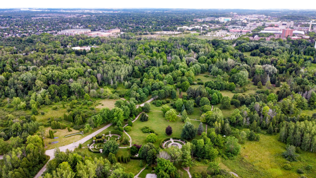 a colour aerial photo of an arboretum in the summer. all the trees are in full floom and the lawns and grasses are gree.
