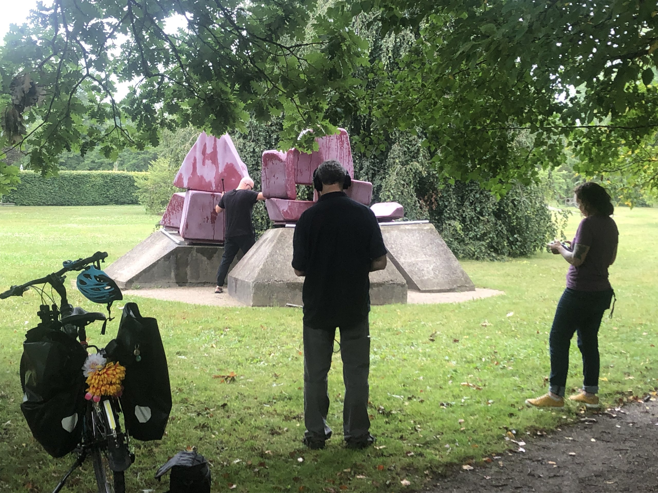 a colour photo of people around a sculpture in a park